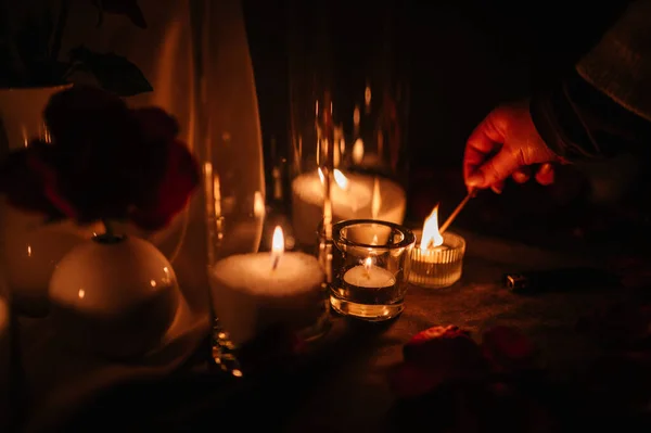 Hands light a candle. Decoration, arrangement and location preparation for surprise marriage proposal. Romantic candlelight dinner at terrace restaurant at night. Place for date or engagement.