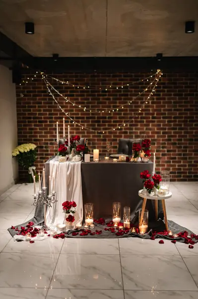 Location for surprise marriage proposal. Table setting in restaurant. Luxury romantic date candlelight at night. Engagement. Decoration flowers, decor candle. Dinner setup for couple on Valentines day