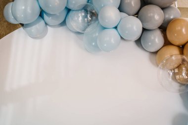 Ayrıntılar. Fotoğraf duvarı dekorasyon alanı, beyaz arkaplanda metin için yer. Mavi, kahverengi, gri balonlarla süslenmiş kemer. Düğün resepsiyonu. Moda dekoru. Kutlama vaftiz kavramı. Doğum günü partisi.