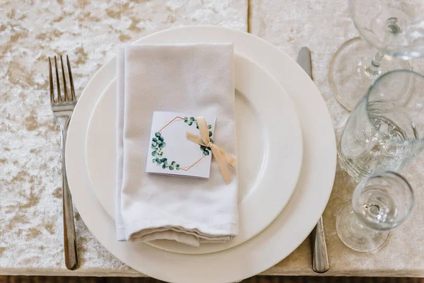 Serving, setting table. Plate decorated linen napkin and silverware cutlery, knife and fork, glasses. flat lay. top view. Close up. Wedding set up, dinner table reception. Birthday, baptism and event.