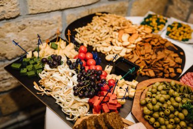 Mini soğuk atıştırmalıklar, halka açık yemek için aperatifler. Tahta tabaklarda yemek, şenlik masasında servis panosu, şirket yemekleri. Büfe masası. Parti ve tatil uzakta. Salon restoranında bir etkinliği dekore etmek..