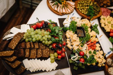 Mini soğuk atıştırmalıklar, halka açık yemek için aperatifler. Tahta tabaklarda yemek, şenlik masasında servis panosu, şirket yemekleri. Büfe masası. Parti ve tatil uzakta. Salon restoranında bir etkinliği dekore etmek..