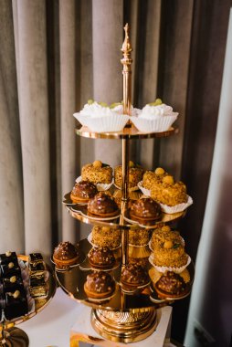 Doğum günü ve vaftizin için tatlı ile birlikte çikolata. Çok lezzetli süslenmiş. Güzel masa. Kek ve kek tabakları. Şekerli masa, açık büfe. Düğün için parti malzemeleri için tatlı masası. Yakın çekim.