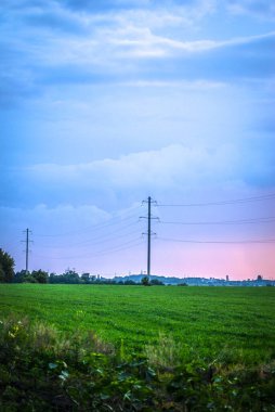 Alanın arka planında yüksek voltajlı elektrik hatları