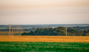 Günbatımının arka planında yüksek voltajlı elektrik hattı