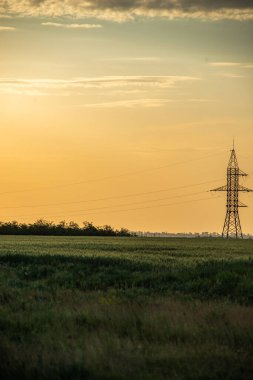 Günbatımı arka planında güç pilonu