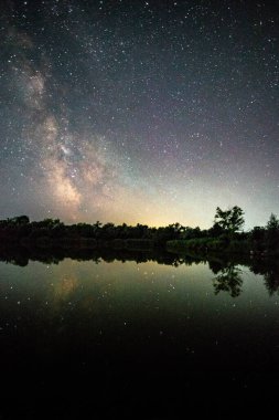 Ağaçlı güzel bir gölün gece görüntüsü.