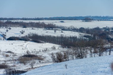 Karlı bir tarlası ve mavi gökyüzü olan bir yer.
