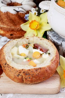 The sour rye soup inside loaf of bread. Easter breakfast table. Festive time