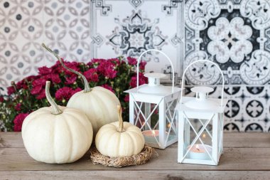 Autumn home decorations in scandinavian style. White baby boo pumpkin and hay wreath. Party decor