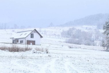 Kırsal kesimde sabahları buzlu ağaçların arasında eski tip bir bina. Güzel kış günü.