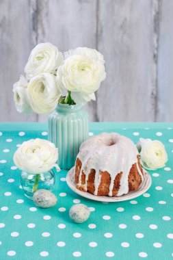 Beyaz Ranunculus (Farsça Buttercup) çiçekler ve turkuaz arka plan üzerinde geleneksel Paskalya pastası, kopya alanı.