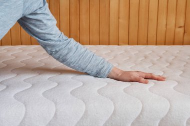 The woman checks the softness of the mattress. Graphic resources