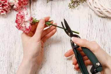 Çiçekçi iş başında. Buket kırmızı ve beyaz Karanfil çiçek yapma kadın.