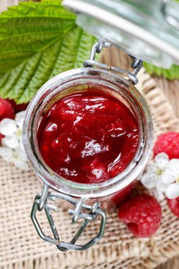 Bowl of raspberry jam on a wooden table. Healthy food