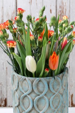 Seramik vazoda bir buket lale ve karanfil. Parti dekoru