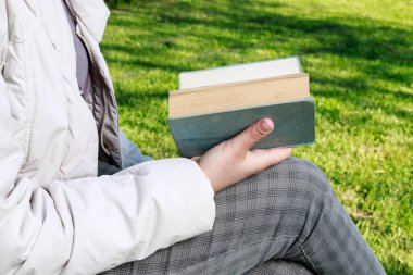 Bahçede kitap okuyan bir kadın. Dinlenme zamanı.