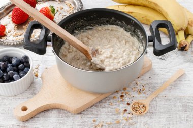 Taze meyvelerin arasında bir tencere yulaf lapası. Sağlıklı yiyecekler. Yemek zamanı.