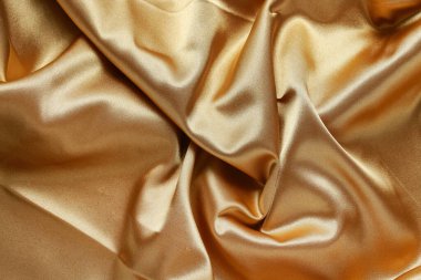 Altın gibi parlak bir kumaş, soyut bir arkaplan. Grafiksel kaynaklar