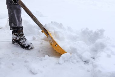 Adam kar fırtınasından sonra kaldırımdan karı kaldırıyor. Kış kıyameti