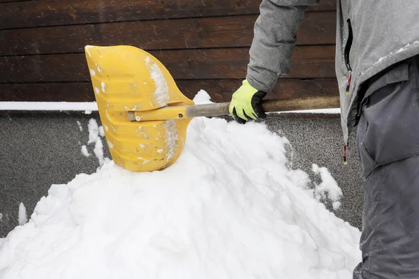 Man removing snow from the sidewalk after snowstorm. Winter apocalypse