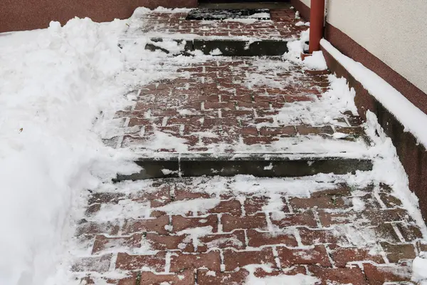 Removing snow from the sidewalk after snowstorm. Winter time