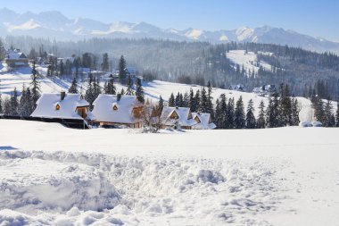 Traditional houses under the snow in Bukowina Tatrzanska, Poland. clipart