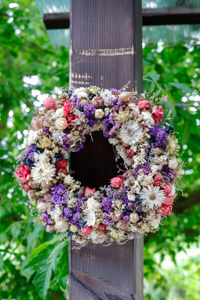 На крыльце висит красивый венок из сухих растений. Декор сада