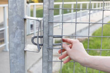 Bir kadın metal bir kapı kilidi açıyor. Sağlam güvenlik girişi