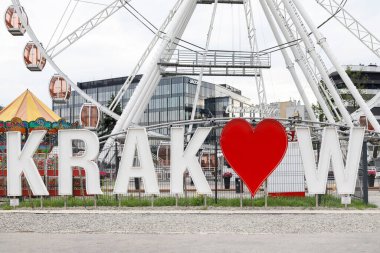 Turistlerin bir lunaparkın arka planında fotoğraf çekebildikleri özgür bir yazı..
