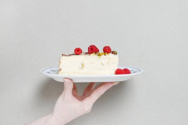 Masada geleneksel cheesecake 'li bir tabakta duran kadın. Parti tatlısı