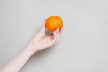Bir kadın elinde sulu bir mandalina tutuyor. Grafiksel kaynaklar