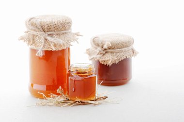 Beyaz arka planda izole edilmiş cam kavanozlardaki bal. Grafiksel kaynaklar