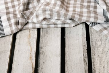 Damalı peçete ahşap bir masanın üzerinde yatıyor. Grafiksel kaynaklar