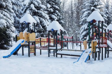 Şehir parkındaki çocuk parkı karla kaplı. Kış zamanı