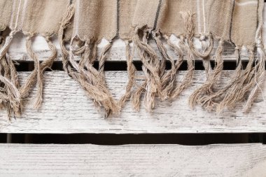 Kumaşın kenarları ahşap bir masanın üzerinde duruyor. Grafiksel kaynaklar