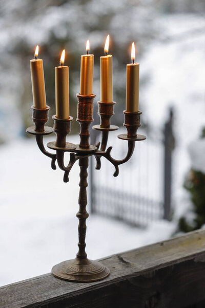 Traditional candle holder on wooden porch in winter. Festive decor