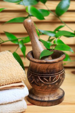 Tahta havan ve havlu yığını masanın üstünde. Spa araçları