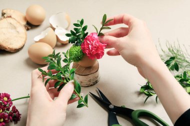 İşteki çiçekçi: kadın yumurta kabuğu ve çeşitli çiçeklerle basit Paskalya süslemesi yapmayı gösteriyor. Adım adım, öğretici.
