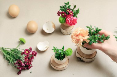 İşteki çiçekçi: kadın yumurta kabuğu ve çeşitli çiçeklerle basit Paskalya süslemesi yapmayı gösteriyor. Adım adım, öğretici.