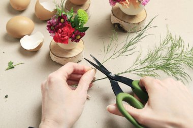 İşteki çiçekçi: kadın yumurta kabuğu ve çeşitli çiçeklerle basit Paskalya süslemesi yapmayı gösteriyor. Adım adım, öğretici.