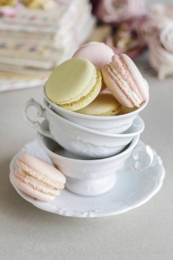 Porselen bardakta Fransız kurabiyeleri. Arka planda güller ve aşk mektupları. Parti tatlısı