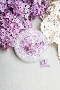 Etrafında bir kase leylak deniz tuzu ve taze çiçekler var. Spa zamanı