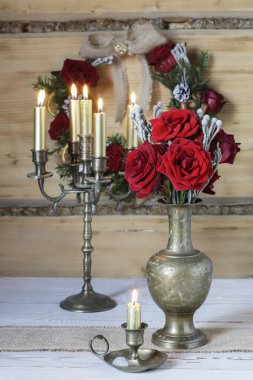 Pirinç mum tutacağı ve kırmızı güllerle romantik dekorasyonlar. Parti dekoru