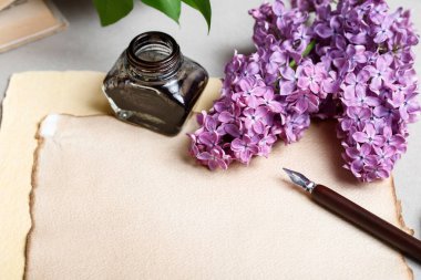 Antika kağıt, mürekkep hokkası, kalem ve leylak çiçekleri, fotokopi alanı. Grafiksel kaynaklar