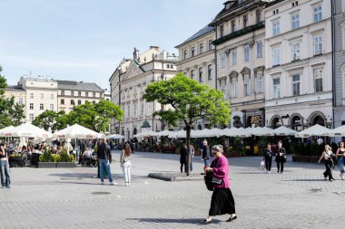 KRAKOW, POLAND - MAYIS 08, 2012: Polonya 'nın Krakow kentindeki Ana Pazar Meydanı' nda (Rynek) turistler. Turistler için tatil yeri