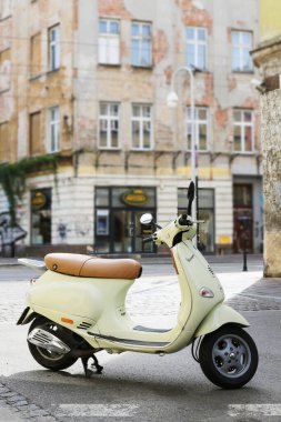 KRAKOW, POLAND - 20 Temmuz 2024 Krakow 'da tarihi bir caddede büyüleyici bir Vespa scooter. Turistler için tatil yeri