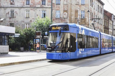 KRAKOW, POLAND - 20 Temmuz 2024: Kazimierz bölgesindeki Krakowa Caddesi 'nde modern bir alt kat tramvayı. Turistler için tatil yeri