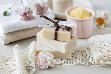 Havlunun üzerinde bir kalıp el yapımı sabun. Diğer kozmetik ürünleri. Dinlenme zamanı.