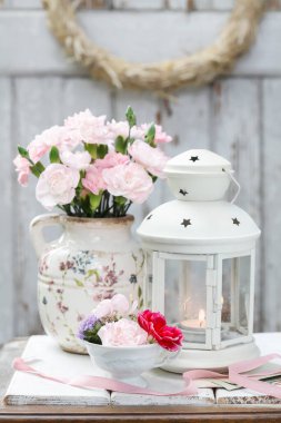 Karanfil çiçekleri ve mumla süslenmiş güzel bir masa süsü. Parti dekoru